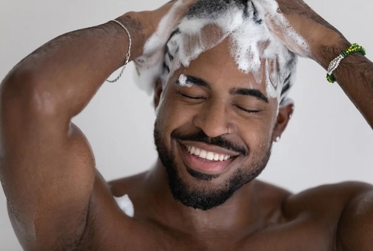 Man lathers his hair with vegan shampoo.