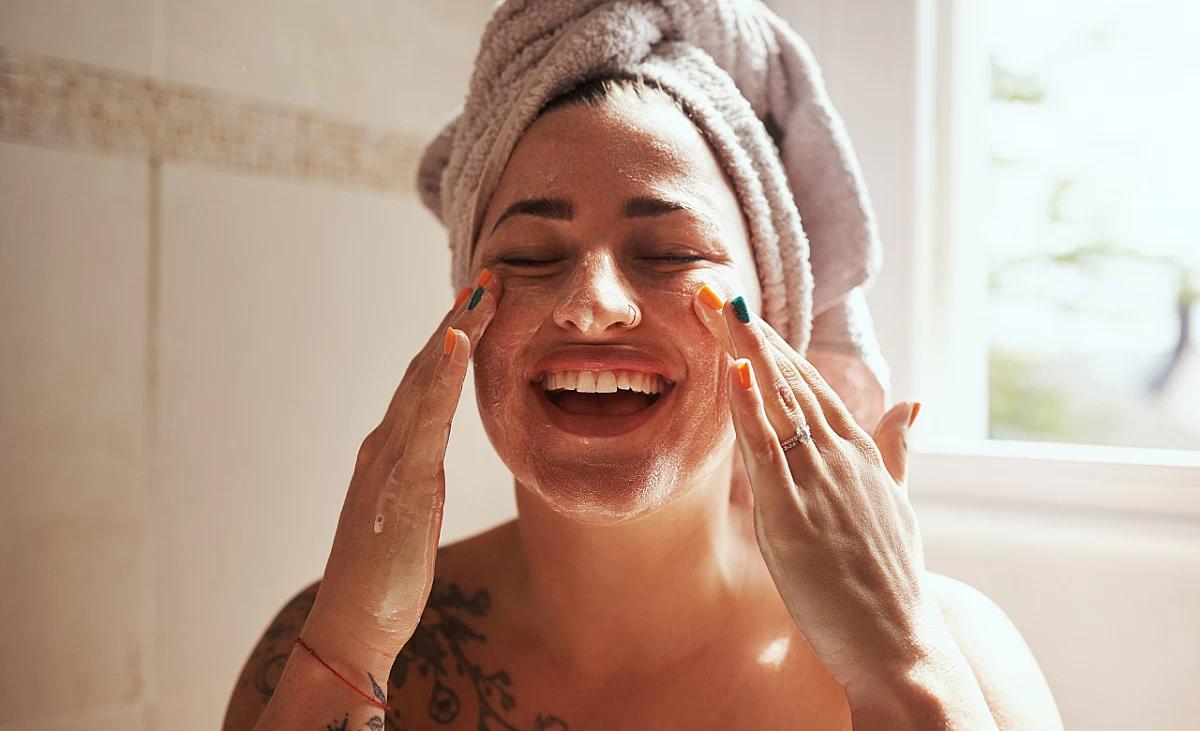 Woman washing her face with cleansing foam.