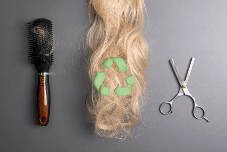 Haarbürste, Haarschere und abgeschnittene Haare mi Recycling Symbol